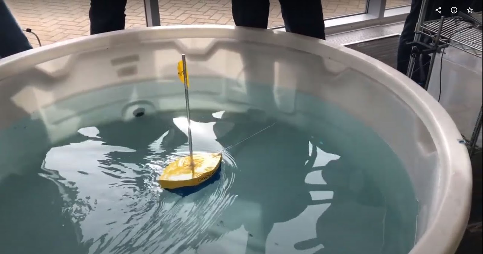 A small boat floating in a tank of water.