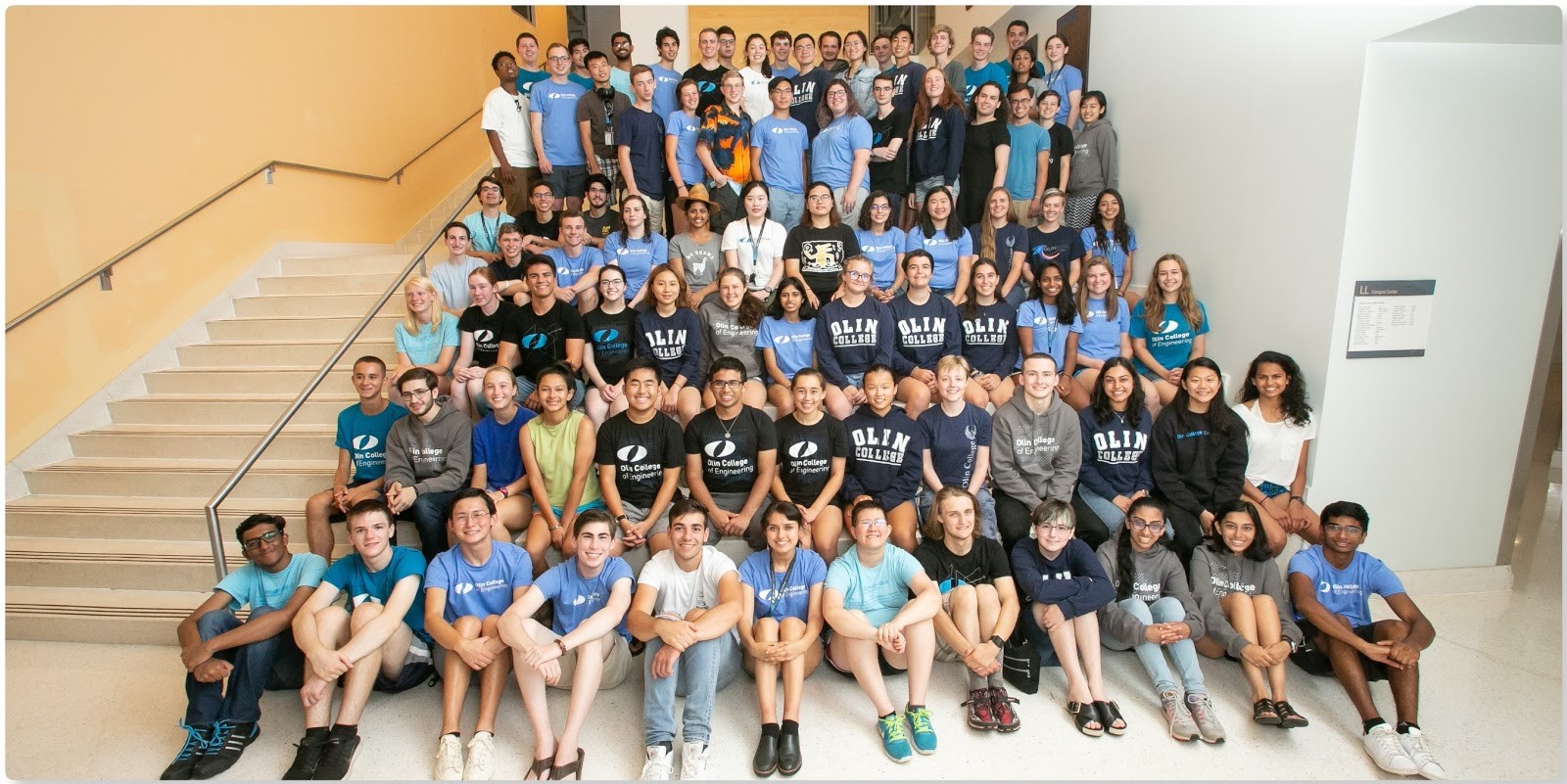 A group picture of a bunch of students, many of whom are wearing Olin shirts.