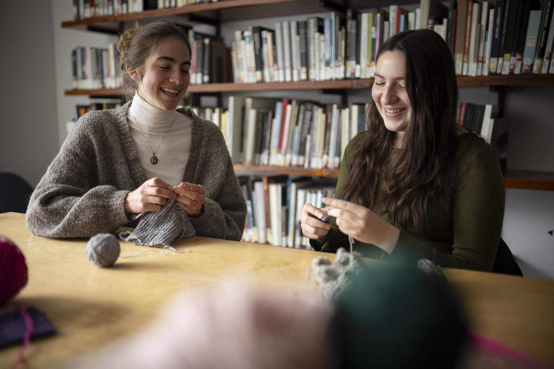 Two Olin students are shown knitting in the Library.