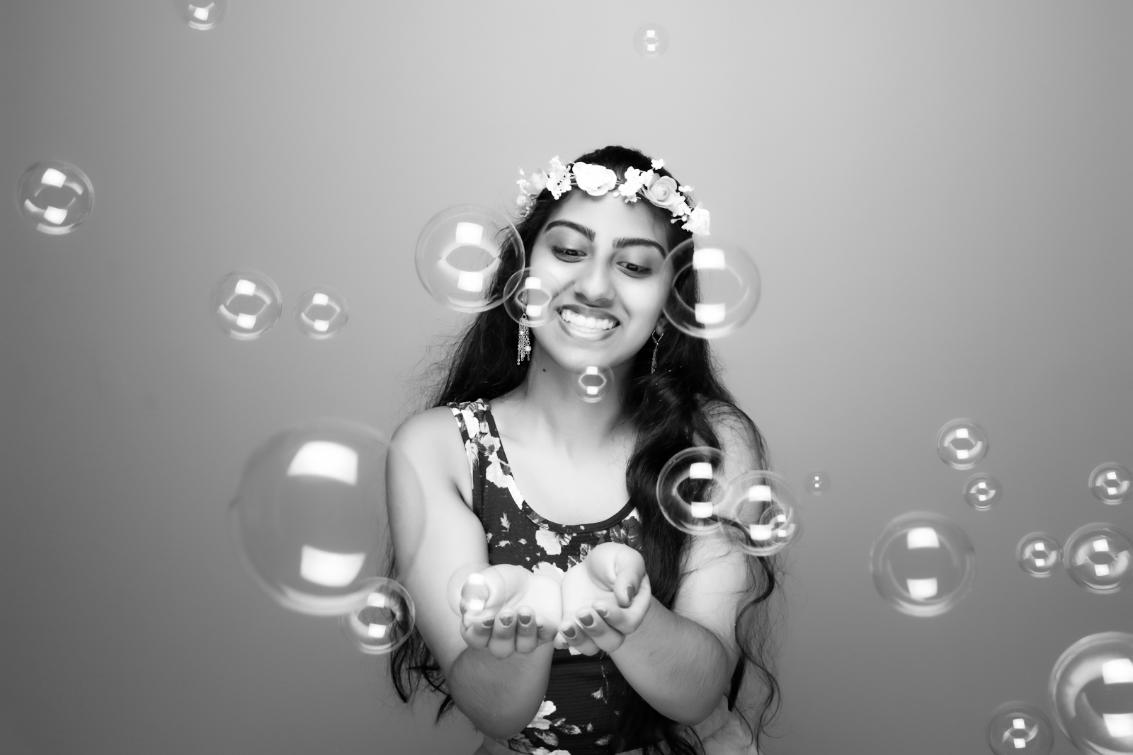 A black-and-white photo of the author with a flower crown and bubbles.