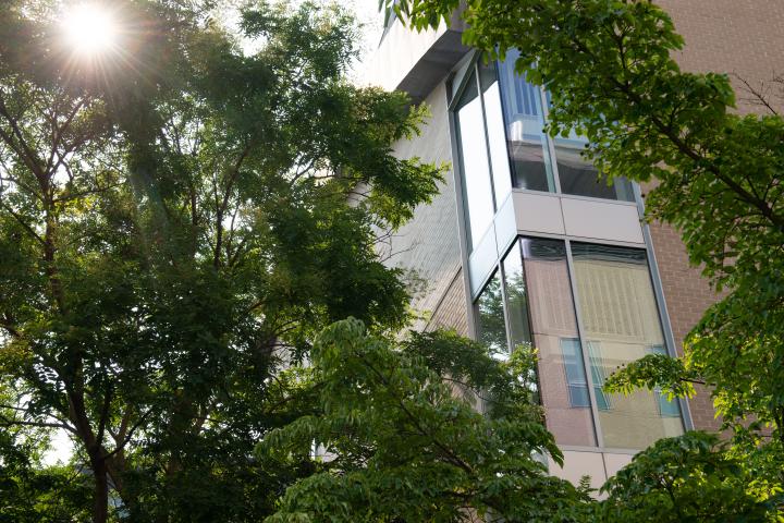 A photo of the corner of a beige colors building with large glass windows