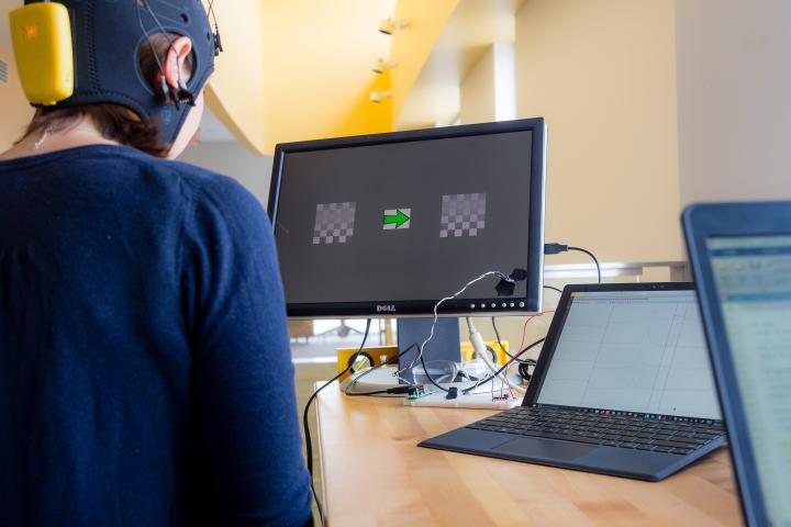 Brain-machine interface research at Olin College of Engineering A photo of a person wearing a head covering with electrodes that is connected to a computer