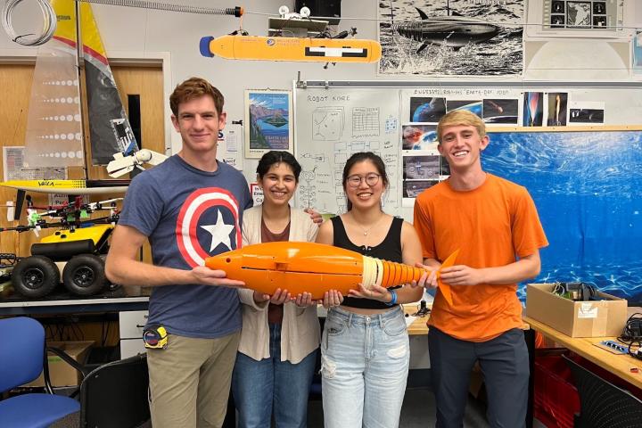 A group of students holding a robotic fish