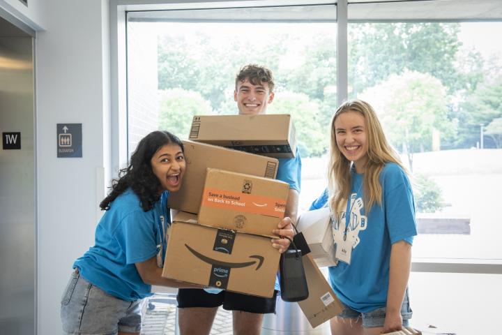 three r2s holding a stack of boxes awaiting the elevator