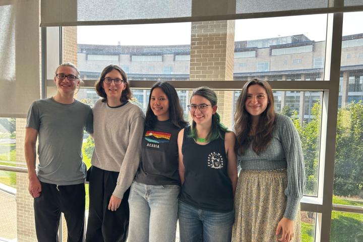 Five students against a window backdrop