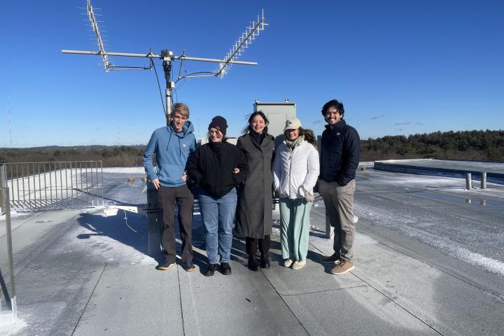 five students outside near an antennae