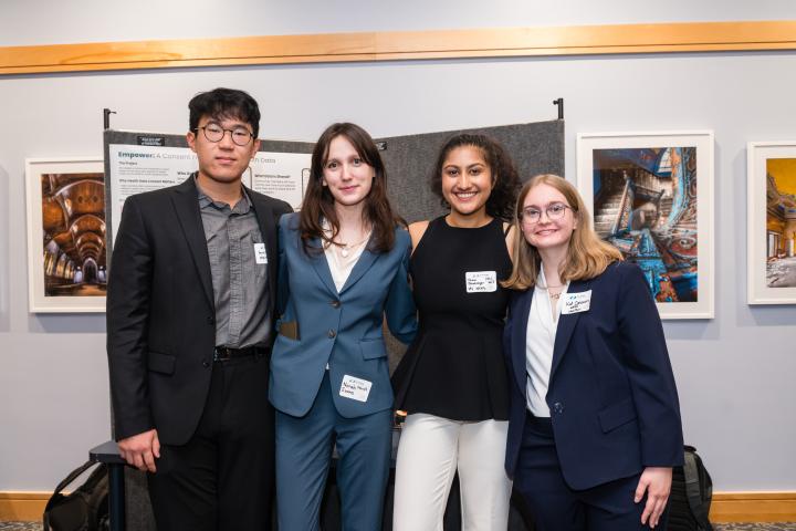 Students posing in front of project poster at Summit