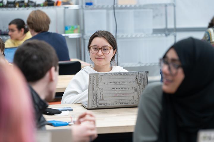 An Olin student sits at a table with laptop open during a recent QEA class.