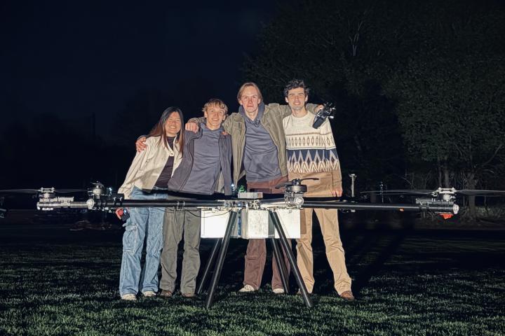 A group photo of OCTAL team members standing with their firefighting drone