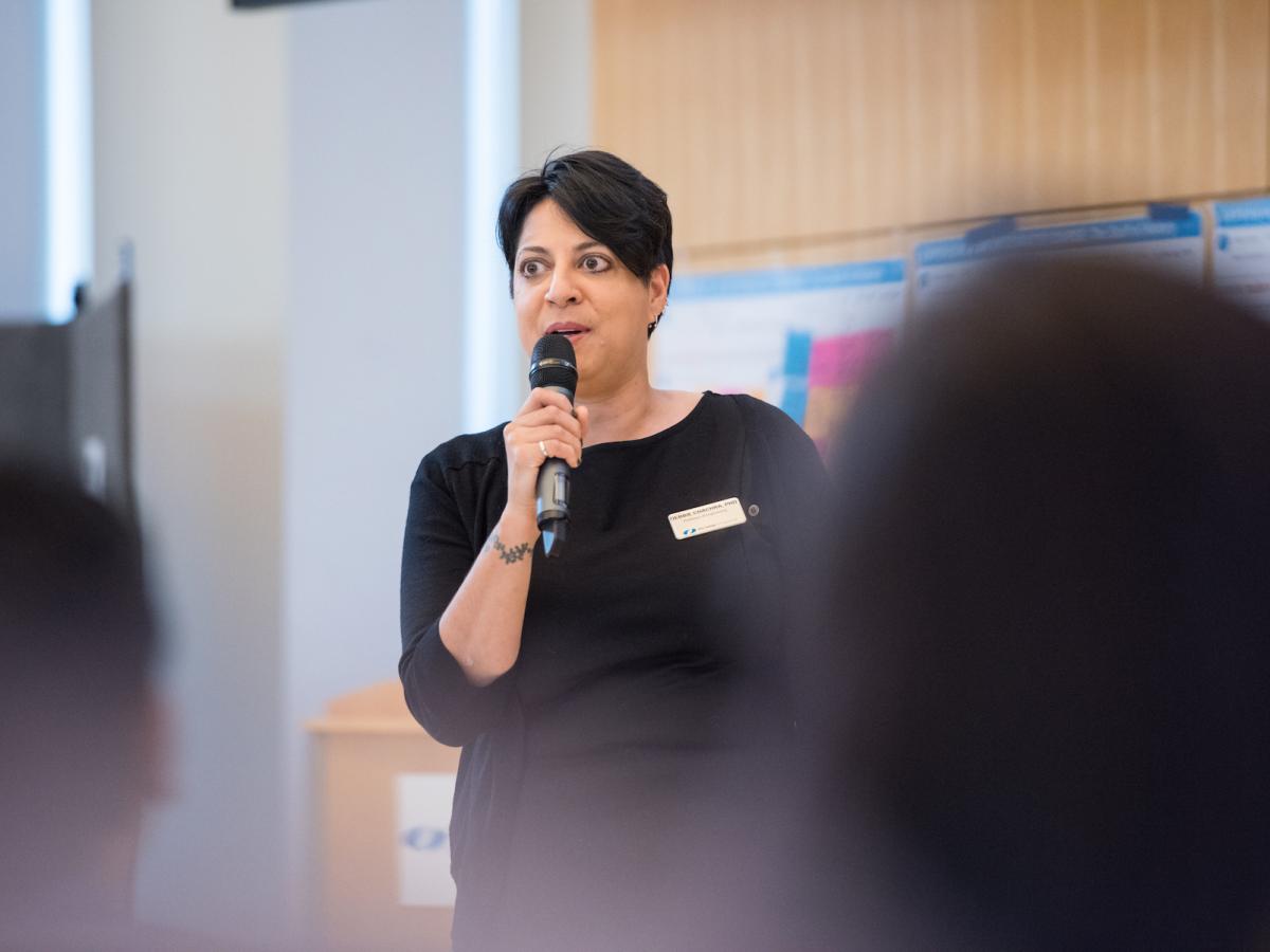 Debbie Chachra, professor of engineering, holds a mic and speaks on campus in 2018.