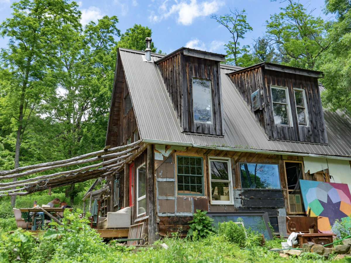 A brown house surrounded by green foliage as part of the larger Woodland Farms