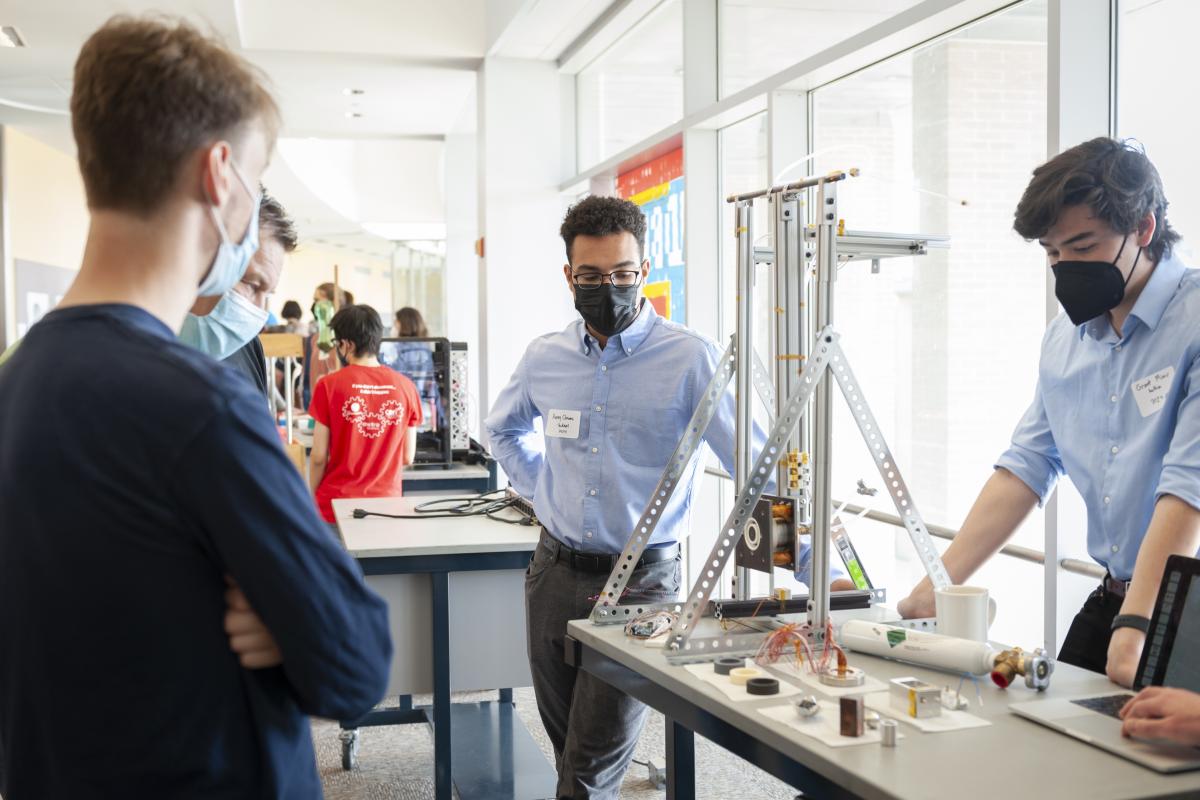 Avery Clowes ‘24 (center) and former Lab member Grant Miner ‘25 (behind table), look at the thruster while interacting with the Olin community during Spring Expo 2022. Photo by Leise Jones. Avery Clowes ‘24 (center) and former Lab member Grant Miner ‘25 (behind table), look at the thruster while interacting with the Olin community during Spring Expo 2022. Photo by Leise Jones.