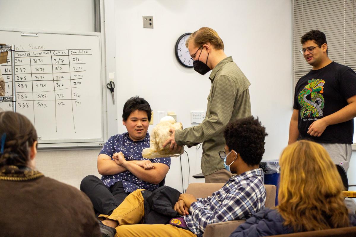 Students show a guest speaker to the classroom a large Lion's Mane mushroom.