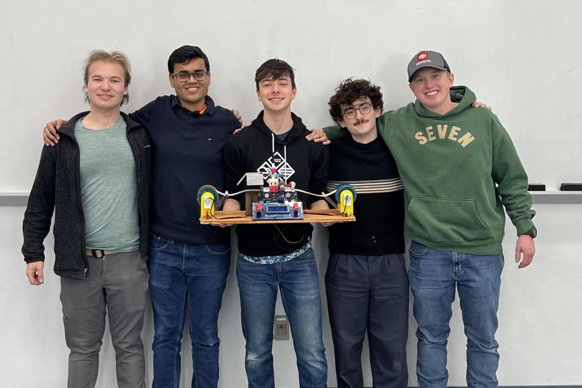 Five Olin College of Engineering students hold up a physical, electromechanical Turing Machine. Five Olin College of Engineering students hold up a physical, electromechanical Turing Machine.