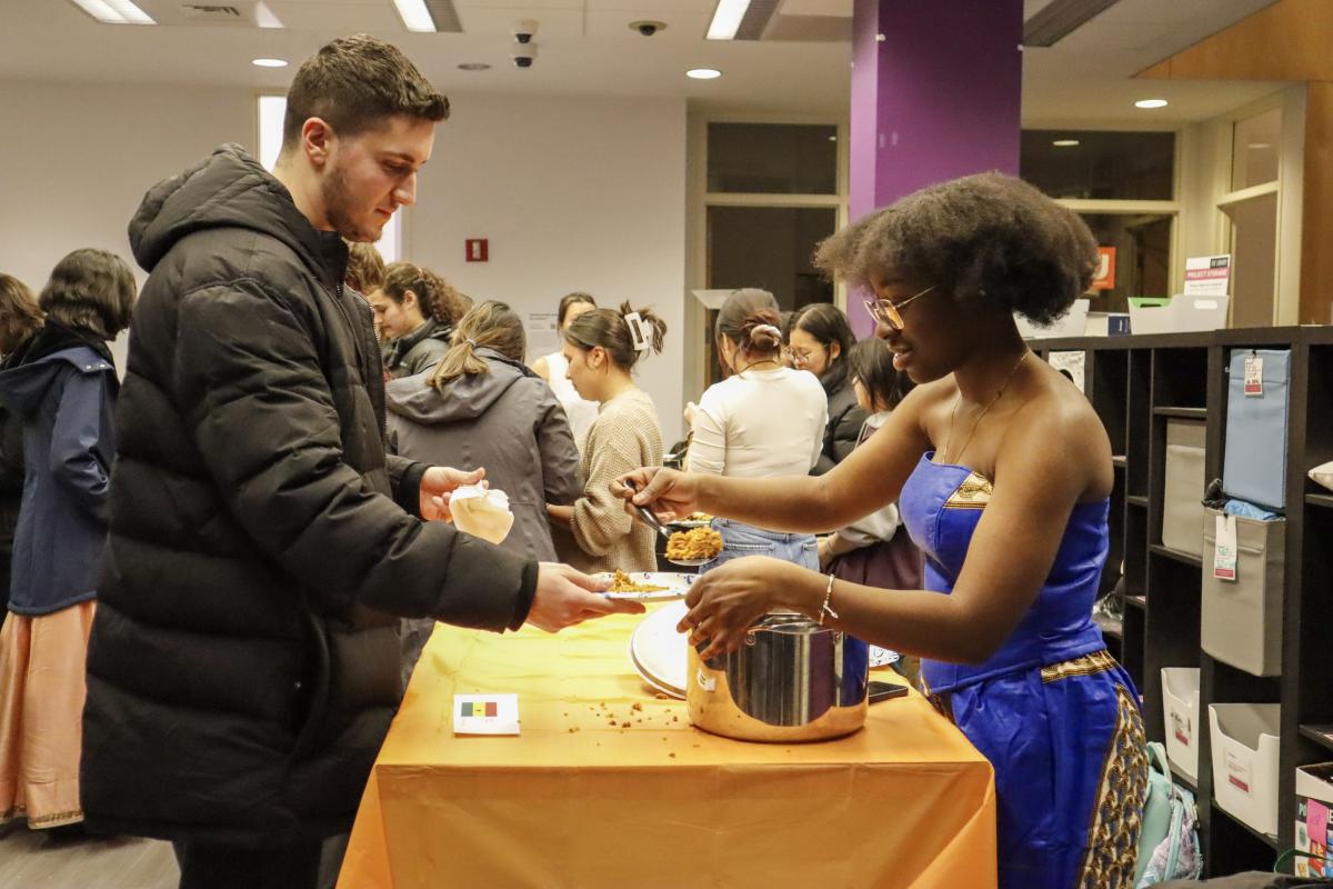A student is served some traditional jollof rice from Ghana at the Olin College Multicultural Fair. A student is served some traditional jollof rice from Ghana at the Olin College Multicultural Fair.