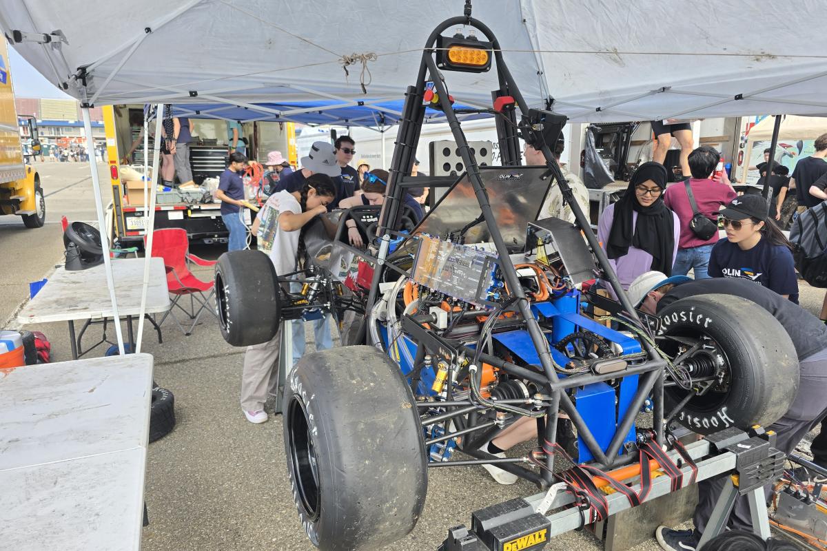 OEM team members work on the electric car MK VII during the SAE Competition in June 2025. 
