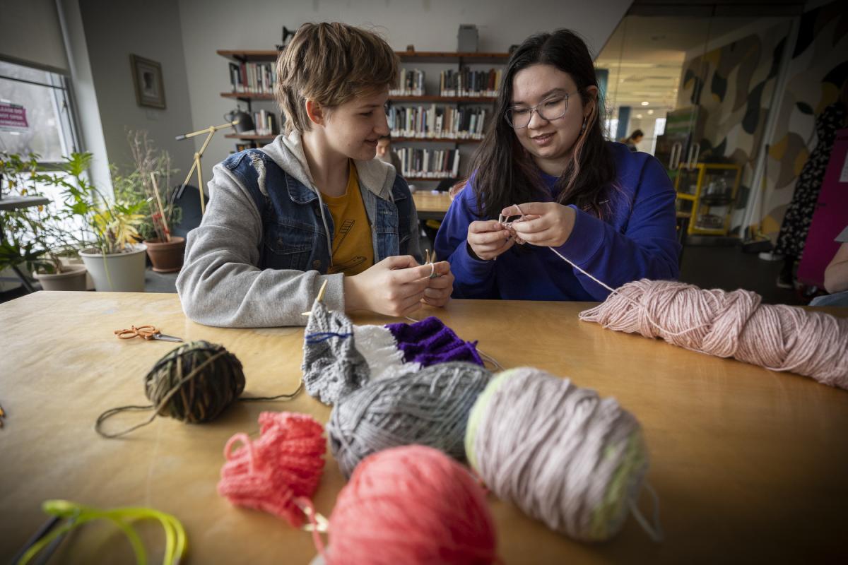 Two students are seen knitting in the Olin Library Reading Room.
