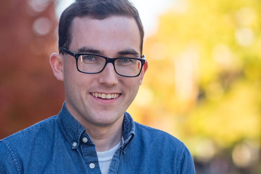 A photo of a young man wearing glasses and smiling