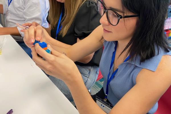 Woman building prototype with Legos while teammates look on