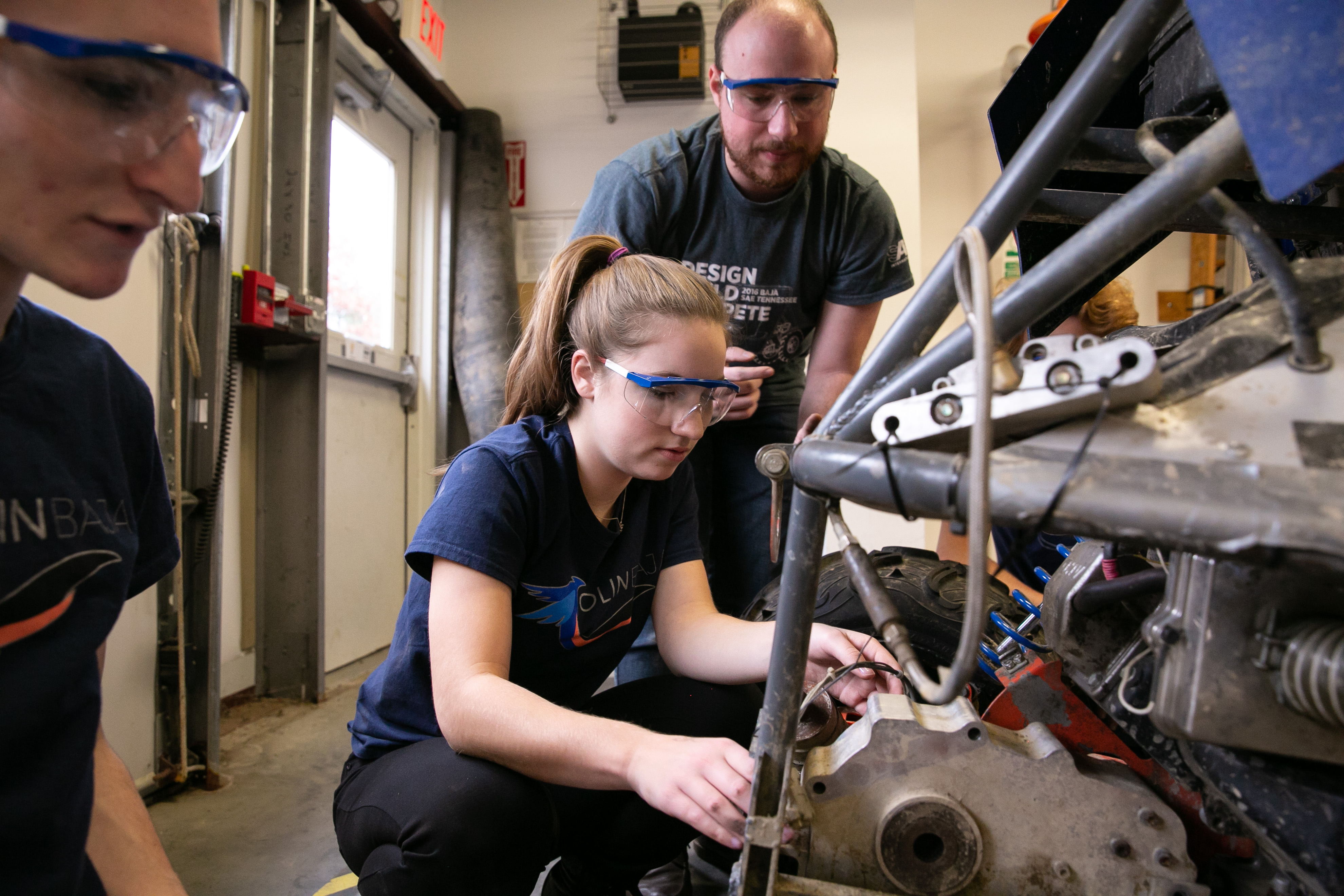 An Olin College of Engineering student, and a member of Baja, works on a vehicle on campus.