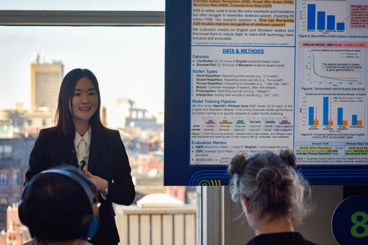 Dongim Lee stands next to a screen with her presentation poster.