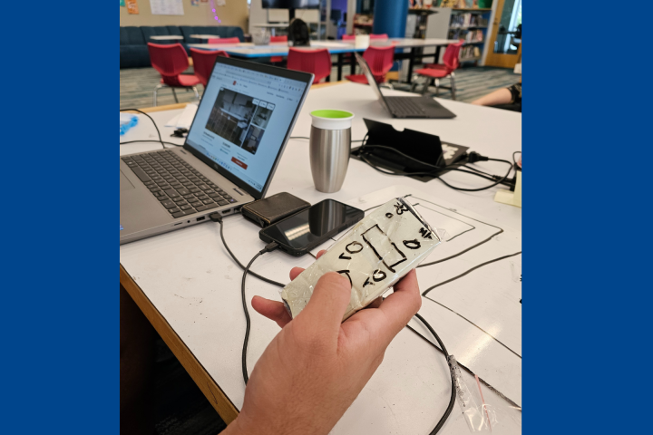 An Olin student holds a prototype in their hand.