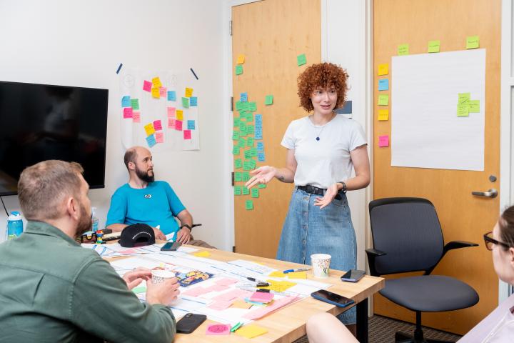 Olin Summer Studio participants engage in immersive program work in a classroom shown with multicolored sticky notes in the background on a wall.