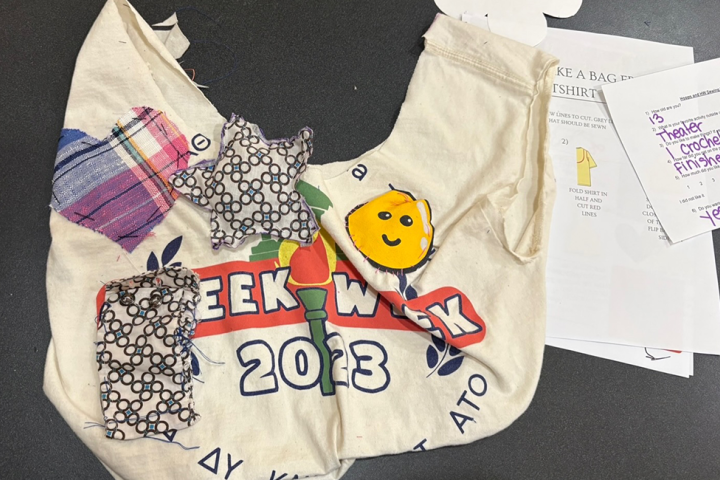 An up-cycled tote bag created in a Products & Markets workshop laying on a black background
