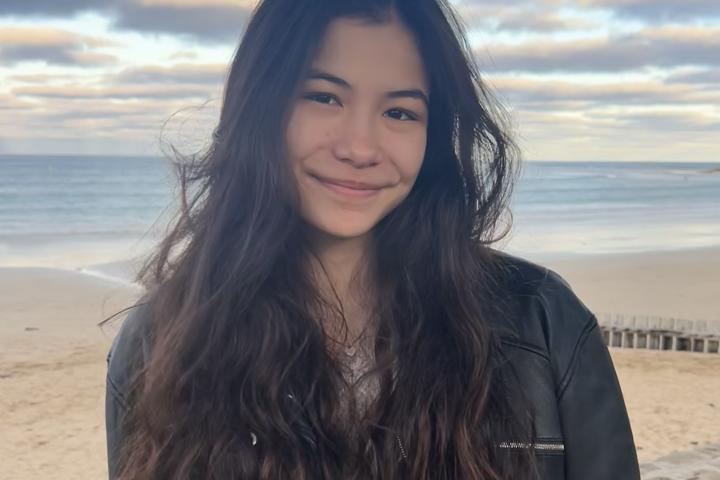 person in black jacket standing on the beach