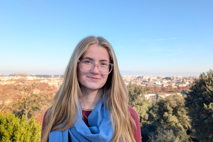 person in glasses stands outdoors