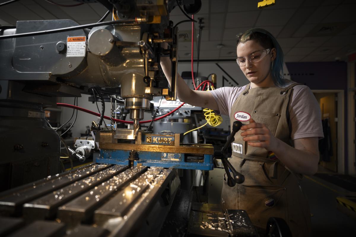 An Oliner works with a machine in the Olin Shop.