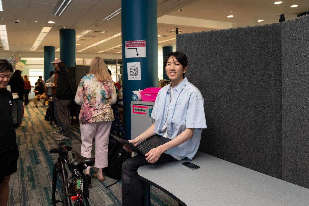 Justin Yoon '29 sits on a table in the Olin Library during Spring Expo 2026