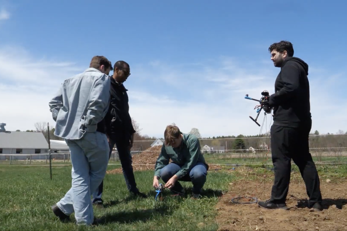 Members of the Olin Robotics Lab operate a HydroFleet Drone in a field