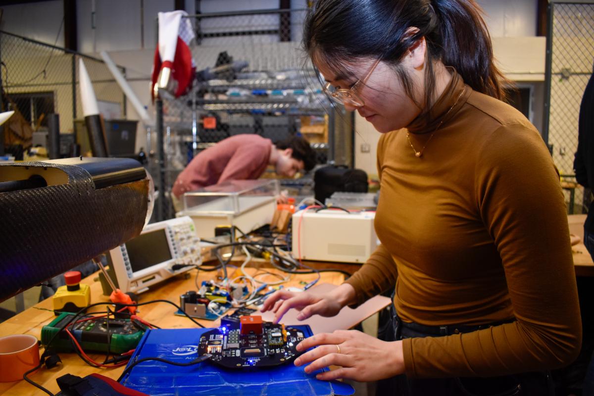 An OCTAL team member working on a circuit board.