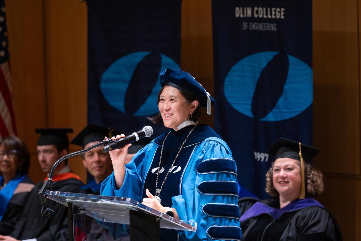 President Lee speaks from the podium on stage in the Norden Auditorium during her inauguration as President of Olin College of Engineering
