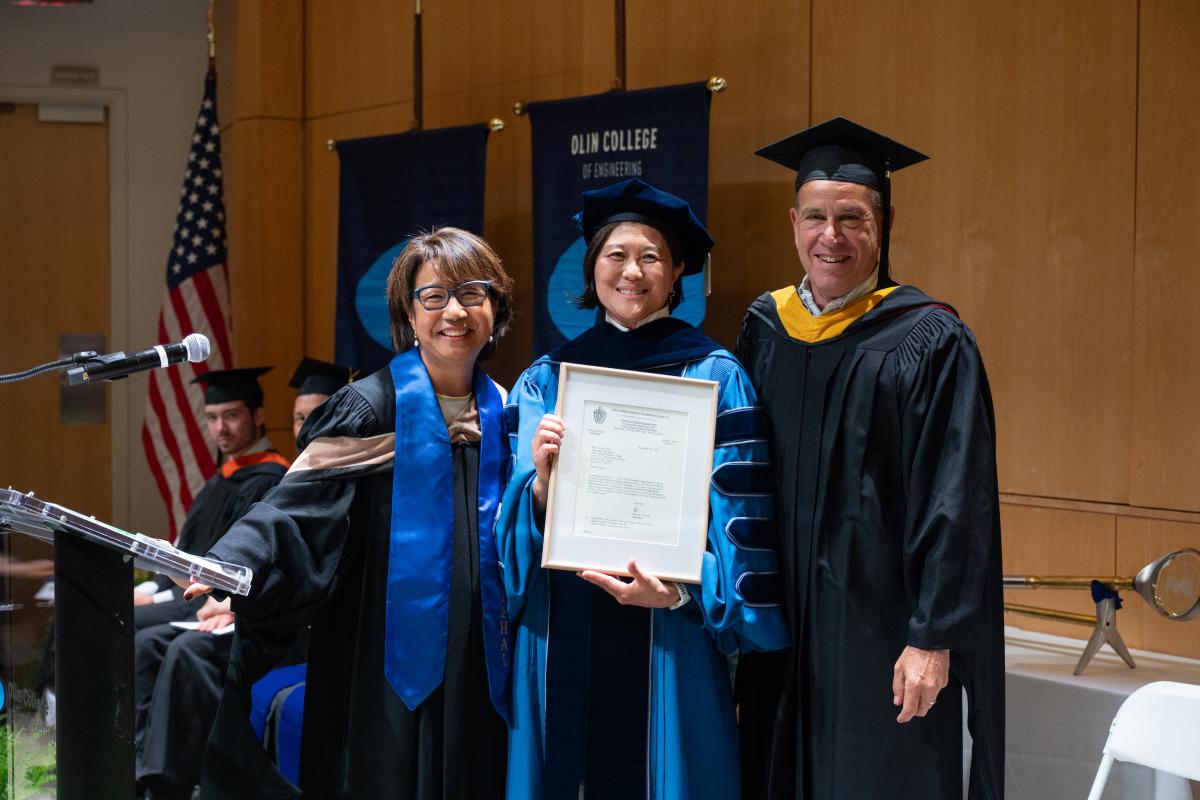 Jeannie Diefenderfer, chair of Olin's Board of Trustees, presents President R. May Lee the Charter of Olin College alongside Trustee Al Bunshaft