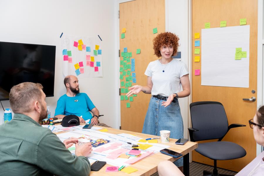 Olin Summer Studio participants engage in immersive program work in a classroom shown with multicolored sticky notes in the background on a wall.