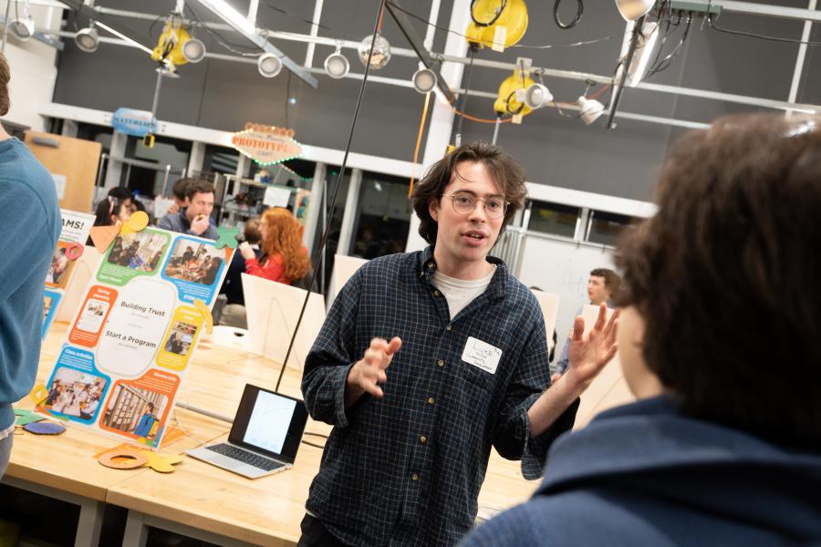 A DJS student talks with an attendee of the DJS Showcase in 2025 about their capstone project.