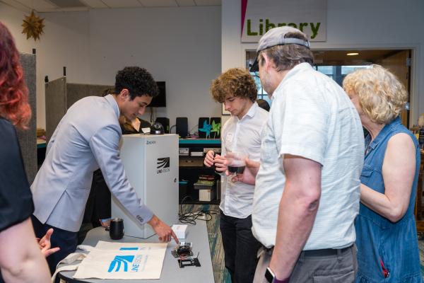 Distance view of students and attendees gathered around poster presentation during SCOPE Summit 