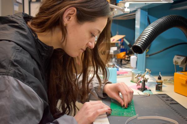 An Olin OAT project team member works at a workbench.