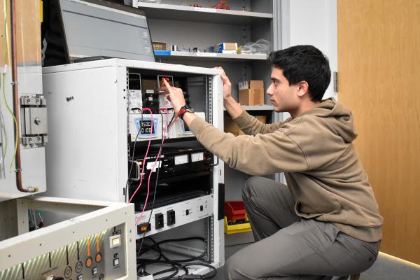 An Olin OPEL project team member crouches down to adjust equipment.