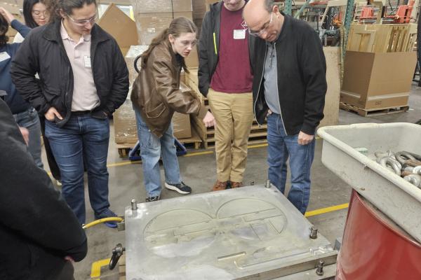 Students and staff learning about Armstrong Mold Corporation.