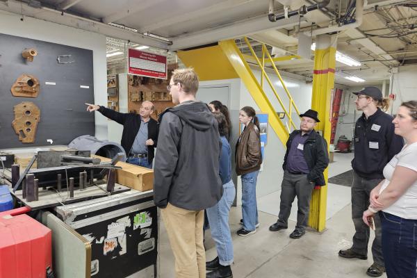 Students and staff receiving a presentation from one of the Students and staff learning about Armstrong Mold Corporation team members. 