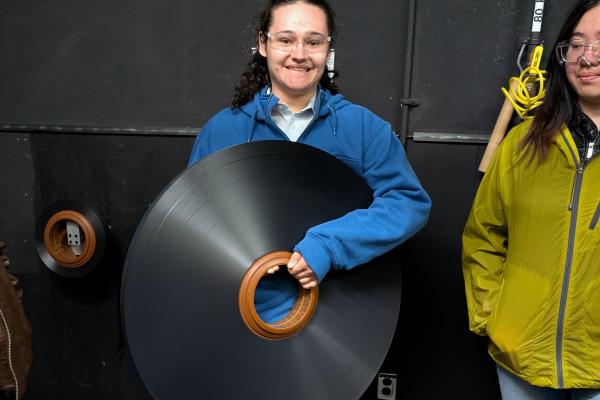 A student poses with a wheel of film. 