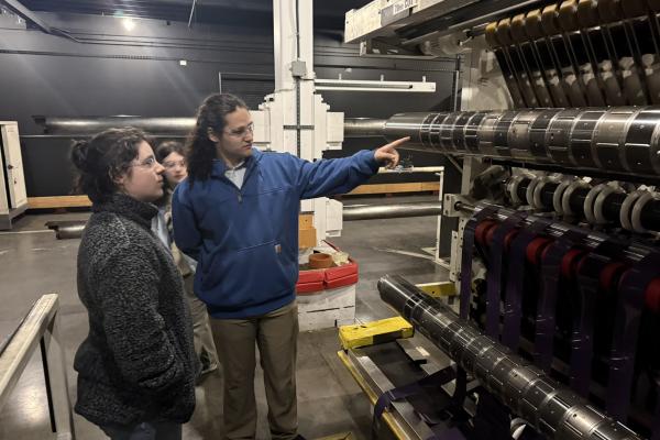 Two students stand in front of a Kodak machine. 