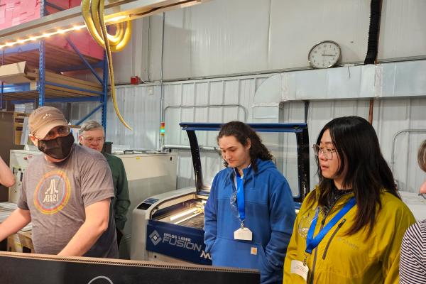 Two students observe a Z-AXIS/Bear Power Supplies team member. 