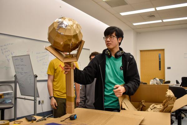 A student with their team's MechProto Design Challenge model.
