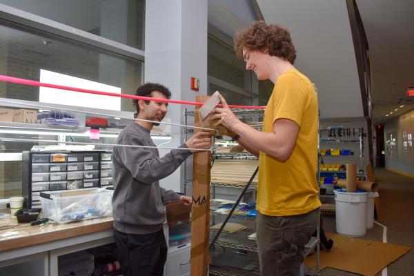 Two students test their MechProto Build Challenge model. 