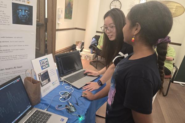 A photo of an IBI member helping a workshop participant with using a sensor..