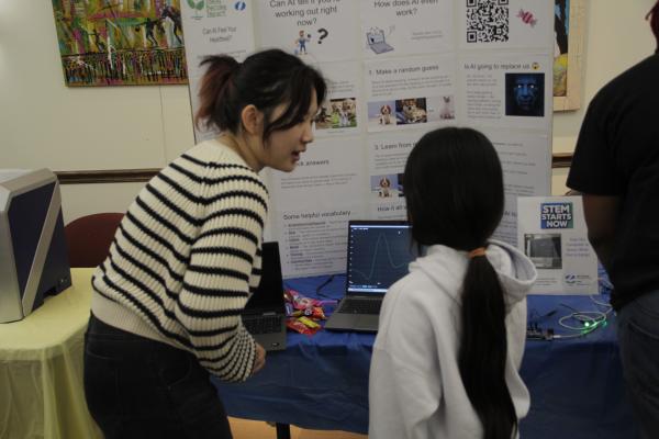 An IBI member is pictured assisting a workshop participant in their project.